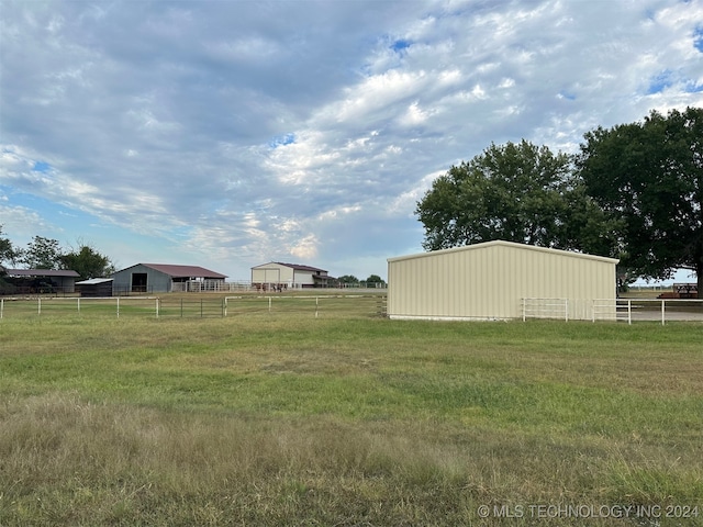 view of yard with an outbuilding and a rural view