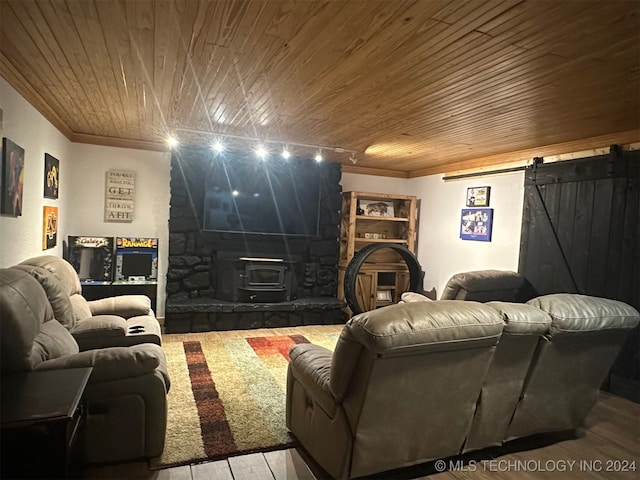 living room with light hardwood / wood-style flooring, a wood stove, wooden ceiling, and a barn door