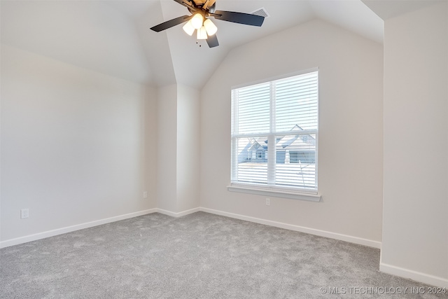 unfurnished room with light carpet, vaulted ceiling, ceiling fan, and a healthy amount of sunlight