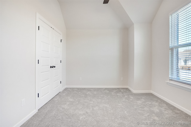 carpeted empty room featuring lofted ceiling and ceiling fan