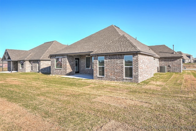 rear view of house featuring a lawn, a patio, and central AC unit