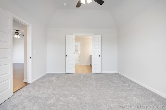 unfurnished bedroom featuring carpet, vaulted ceiling, ceiling fan, and ensuite bathroom