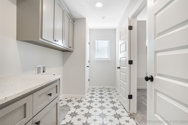 washroom with hookup for a washing machine and cabinets