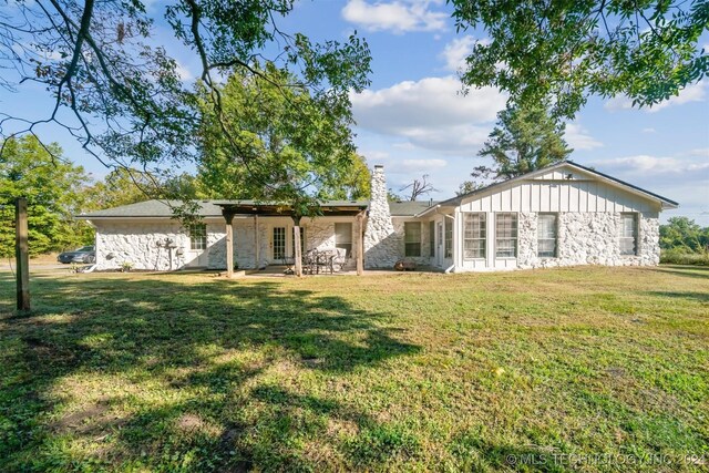 rear view of property with a yard