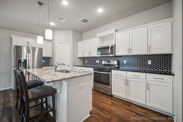 kitchen featuring an island with sink, sink, dark wood-type flooring, white cabinetry, and appliances with stainless steel finishes