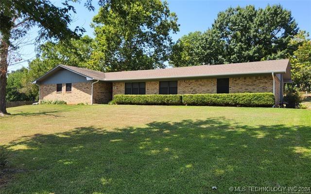 ranch-style home featuring brick siding and a front yard