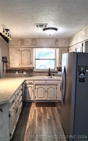 kitchen with a textured ceiling, stainless steel fridge, dark hardwood / wood-style flooring, and sink