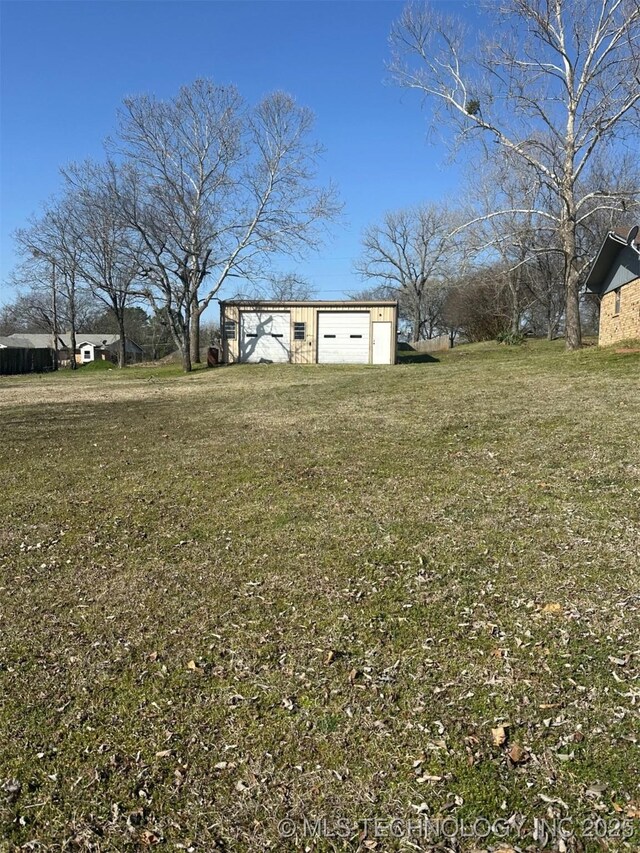 view of yard with an outdoor structure, a garage, and driveway