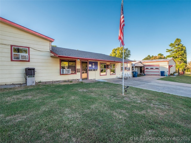 view of front of house featuring cooling unit, a garage, and a front yard