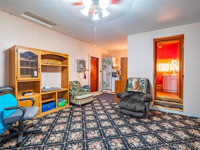 living area with a textured ceiling, a wall mounted AC, and ceiling fan