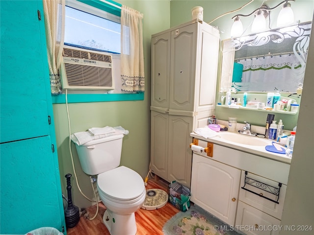 bathroom featuring wood-type flooring, vanity, toilet, and cooling unit