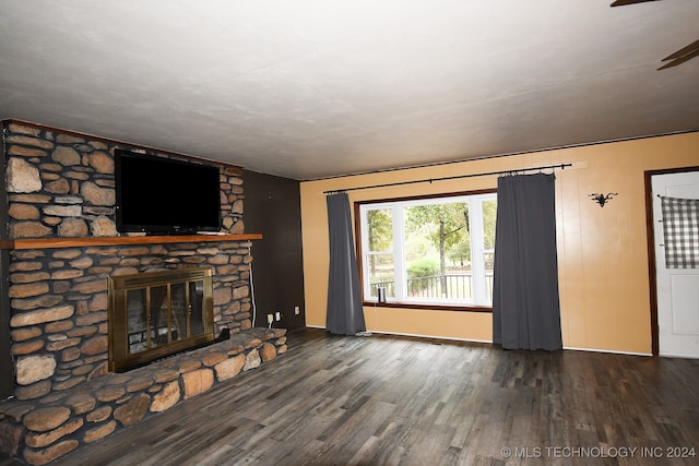 unfurnished living room featuring ceiling fan, a fireplace, and dark wood-type flooring