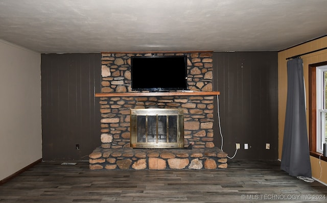 unfurnished living room with wood walls, dark hardwood / wood-style floors, and a fireplace