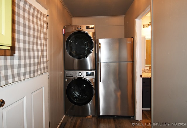 laundry room with stacked washing maching and dryer and dark hardwood / wood-style flooring