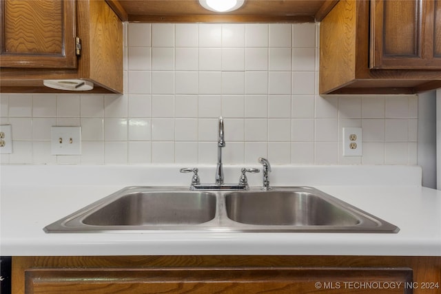 kitchen with backsplash, wall chimney range hood, and sink