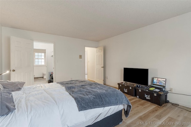 bedroom with light wood finished floors and a textured ceiling