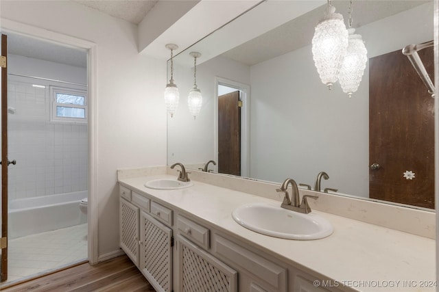 full bathroom with vanity, hardwood / wood-style flooring, a chandelier, toilet, and tiled shower / bath