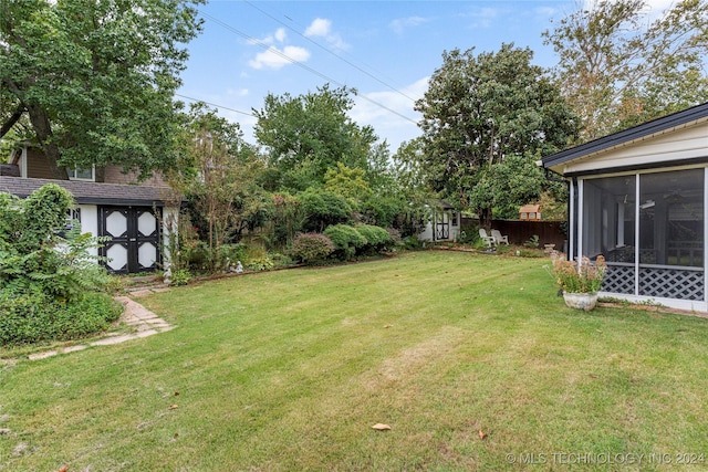 view of yard featuring a storage shed and a sunroom