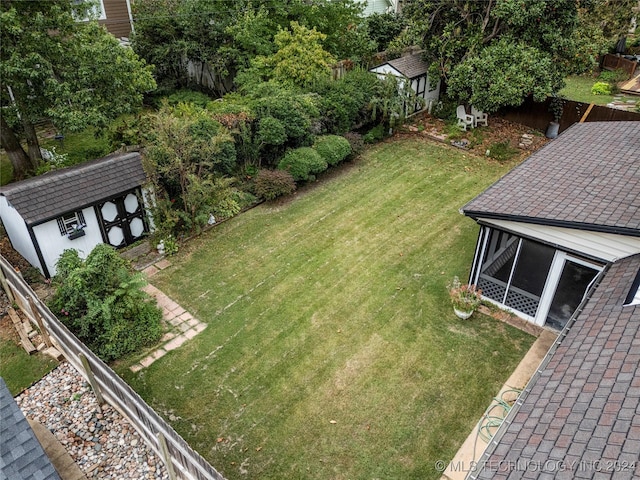 view of yard with a sunroom and a shed