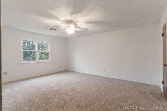 empty room with a textured ceiling, carpet floors, and ceiling fan