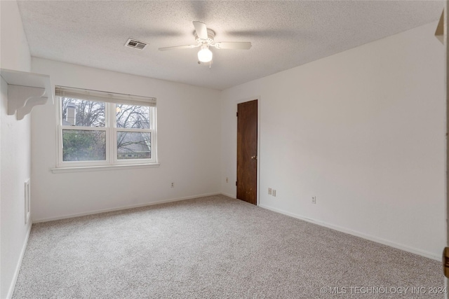 unfurnished room featuring carpet flooring, ceiling fan, and a textured ceiling