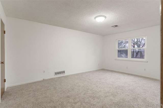 unfurnished room featuring a textured ceiling and carpet floors