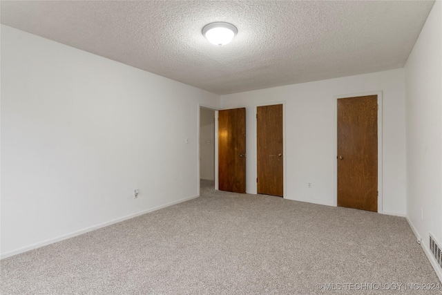 unfurnished bedroom featuring carpet flooring and a textured ceiling