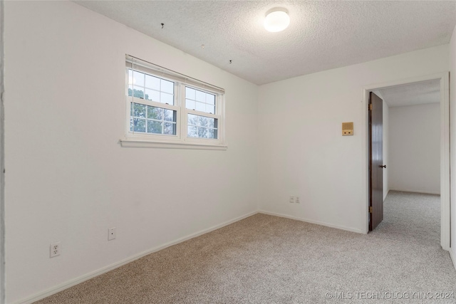 carpeted spare room with a textured ceiling