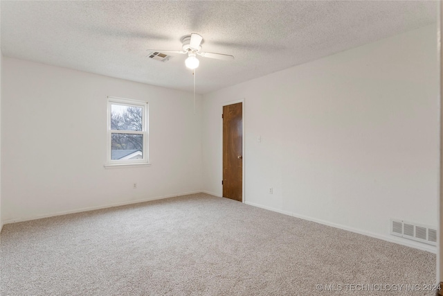 spare room with carpet flooring, ceiling fan, and a textured ceiling