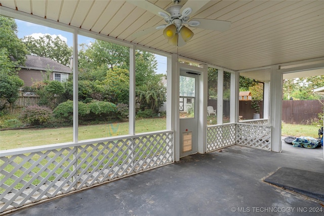 unfurnished sunroom with ceiling fan