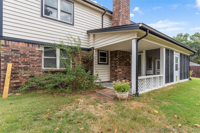 exterior space featuring a lawn and a sunroom