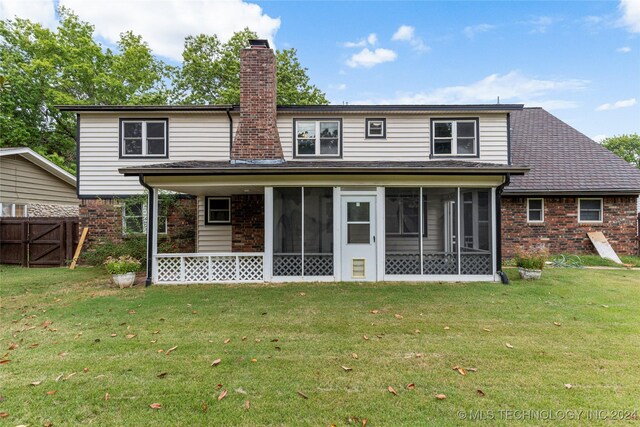 back of property with a sunroom and a yard