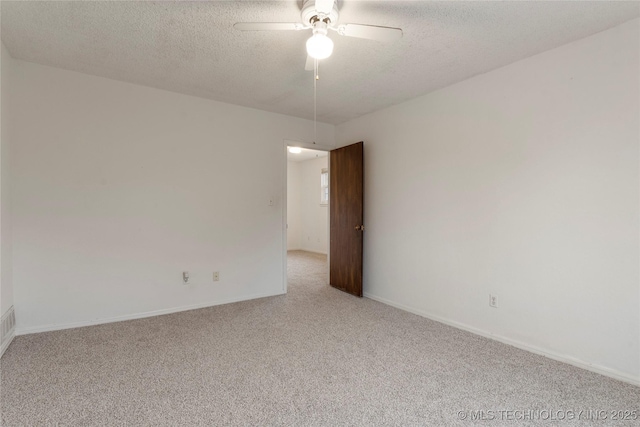 unfurnished room with light carpet, ceiling fan, a textured ceiling, and baseboards