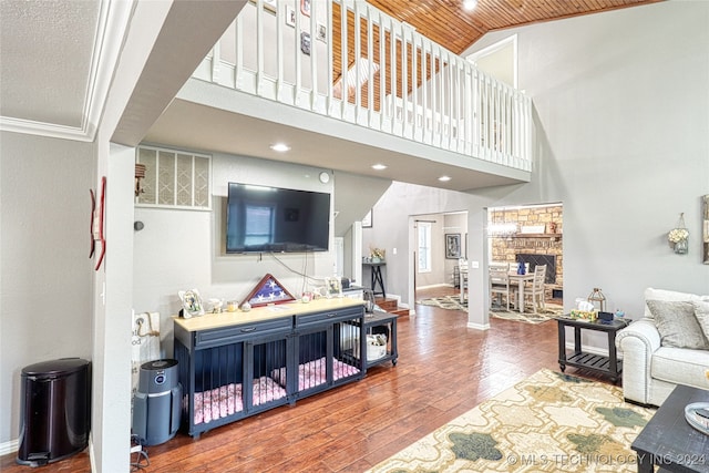 living room with hardwood / wood-style floors, wooden ceiling, high vaulted ceiling, and ornamental molding