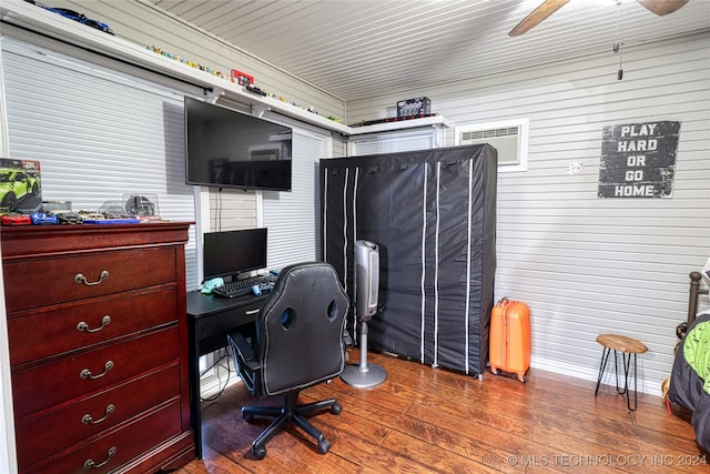 office area featuring hardwood / wood-style floors, ceiling fan, and wood walls