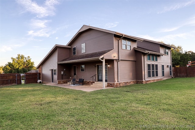 back of property with a yard and a patio