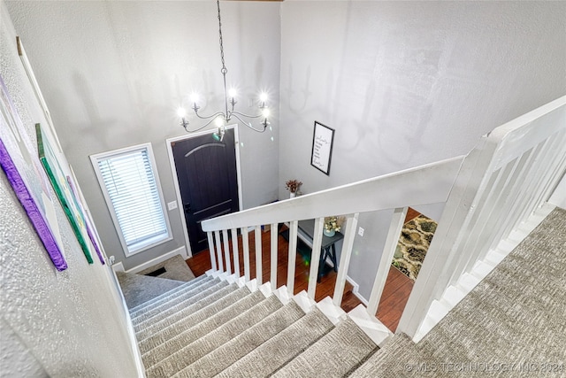 stairs with a towering ceiling and wood-type flooring