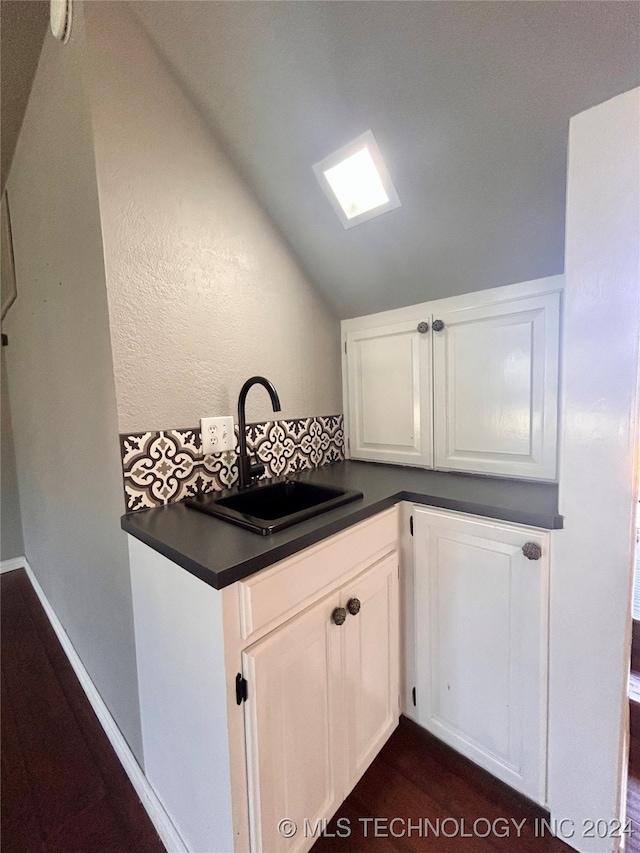 kitchen featuring sink, white cabinets, and vaulted ceiling