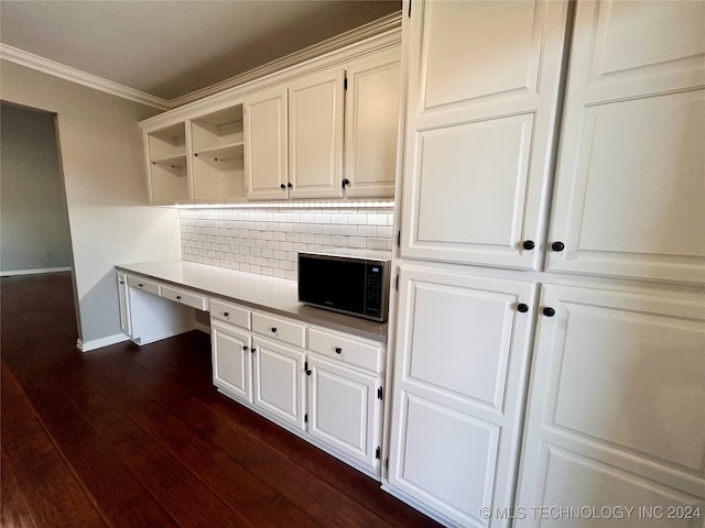 interior space featuring ornamental molding, built in desk, and dark wood-type flooring