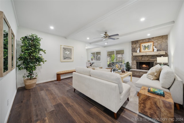 living room with a stone fireplace, beam ceiling, dark wood-type flooring, and ceiling fan