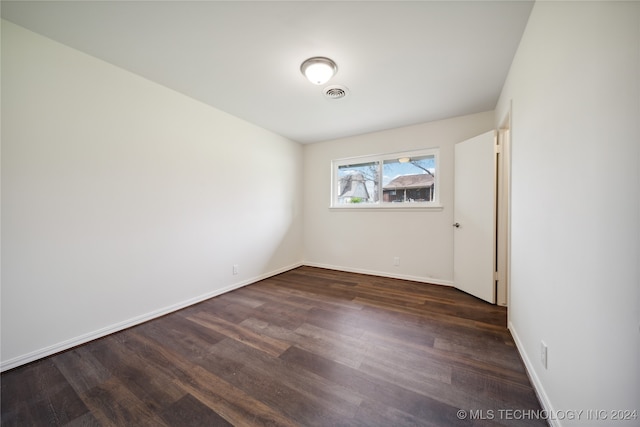 unfurnished room with dark hardwood / wood-style flooring