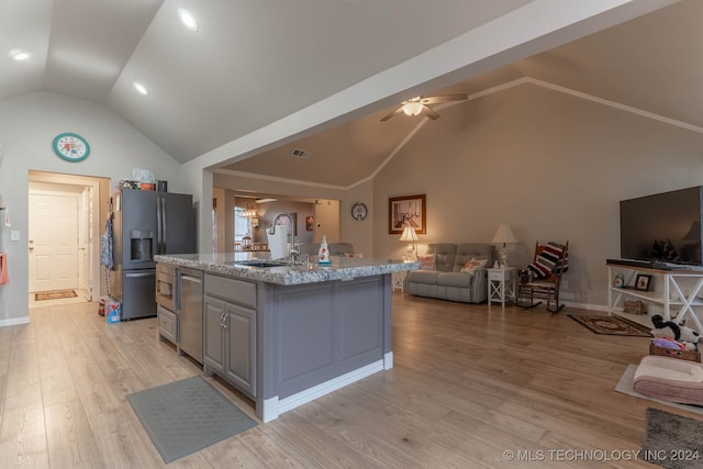 kitchen featuring a kitchen island with sink, sink, vaulted ceiling, appliances with stainless steel finishes, and ceiling fan