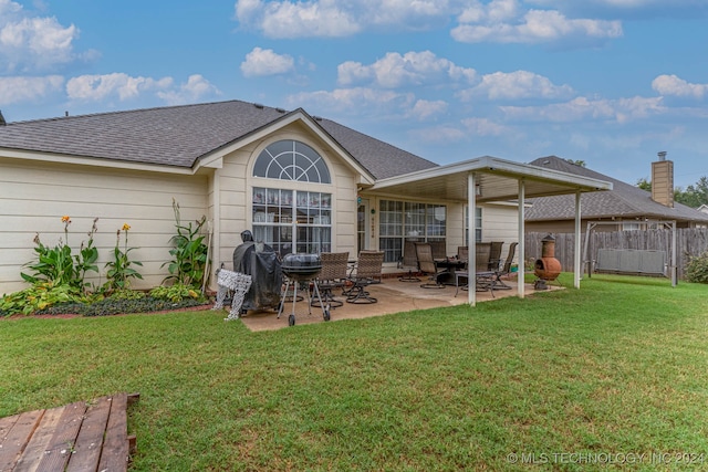 rear view of house with a lawn and a patio area