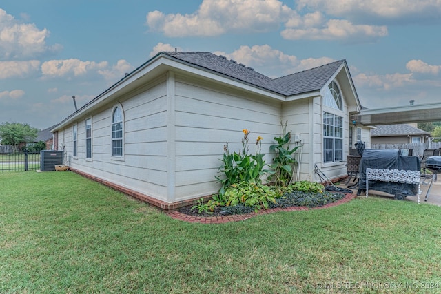 view of home's exterior with a lawn and central air condition unit