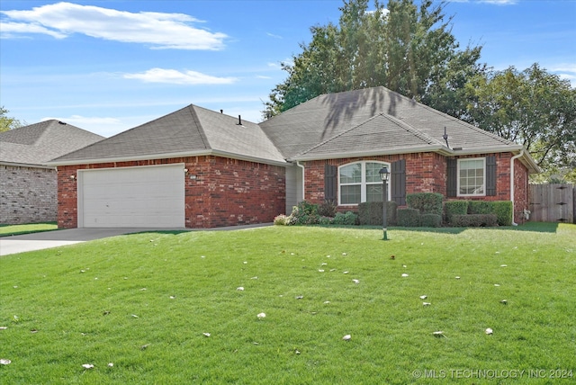 single story home with a garage and a front lawn