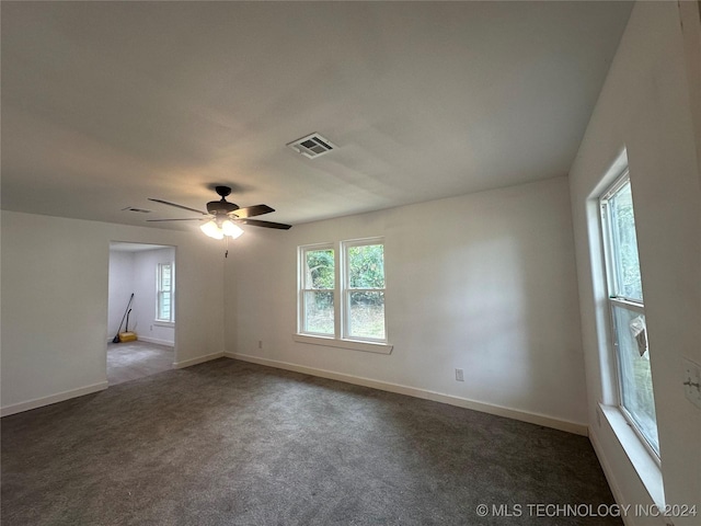 spare room with dark carpet, plenty of natural light, and ceiling fan