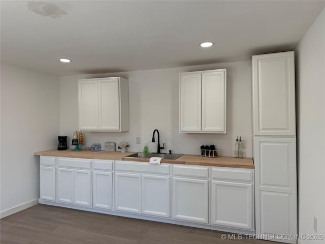 kitchen featuring light wood-type flooring, white cabinetry, and sink