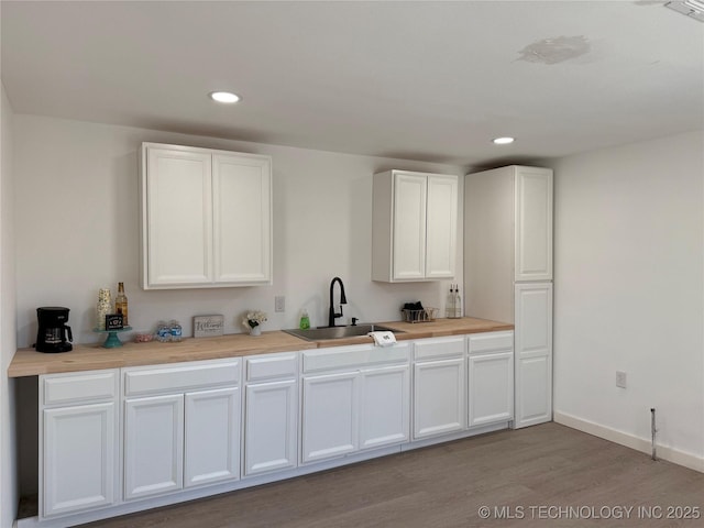 kitchen featuring white cabinets, light hardwood / wood-style floors, and sink