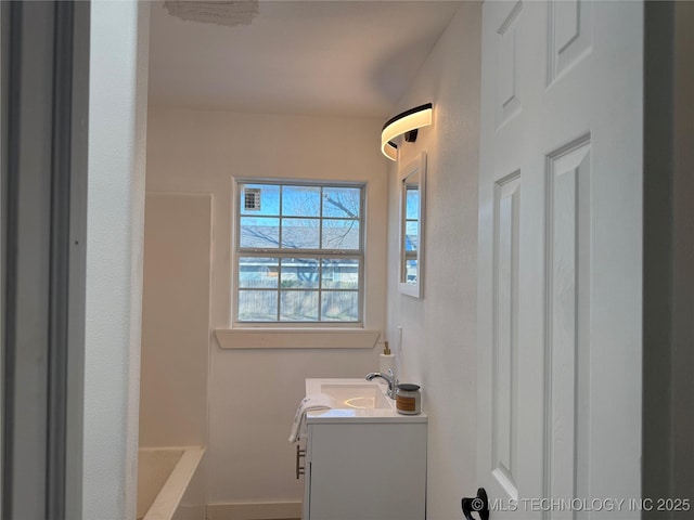 bathroom with a bathing tub and vanity