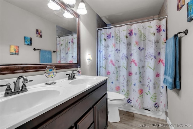 full bathroom featuring shower / bath combo with shower curtain, wood-type flooring, vanity, and toilet